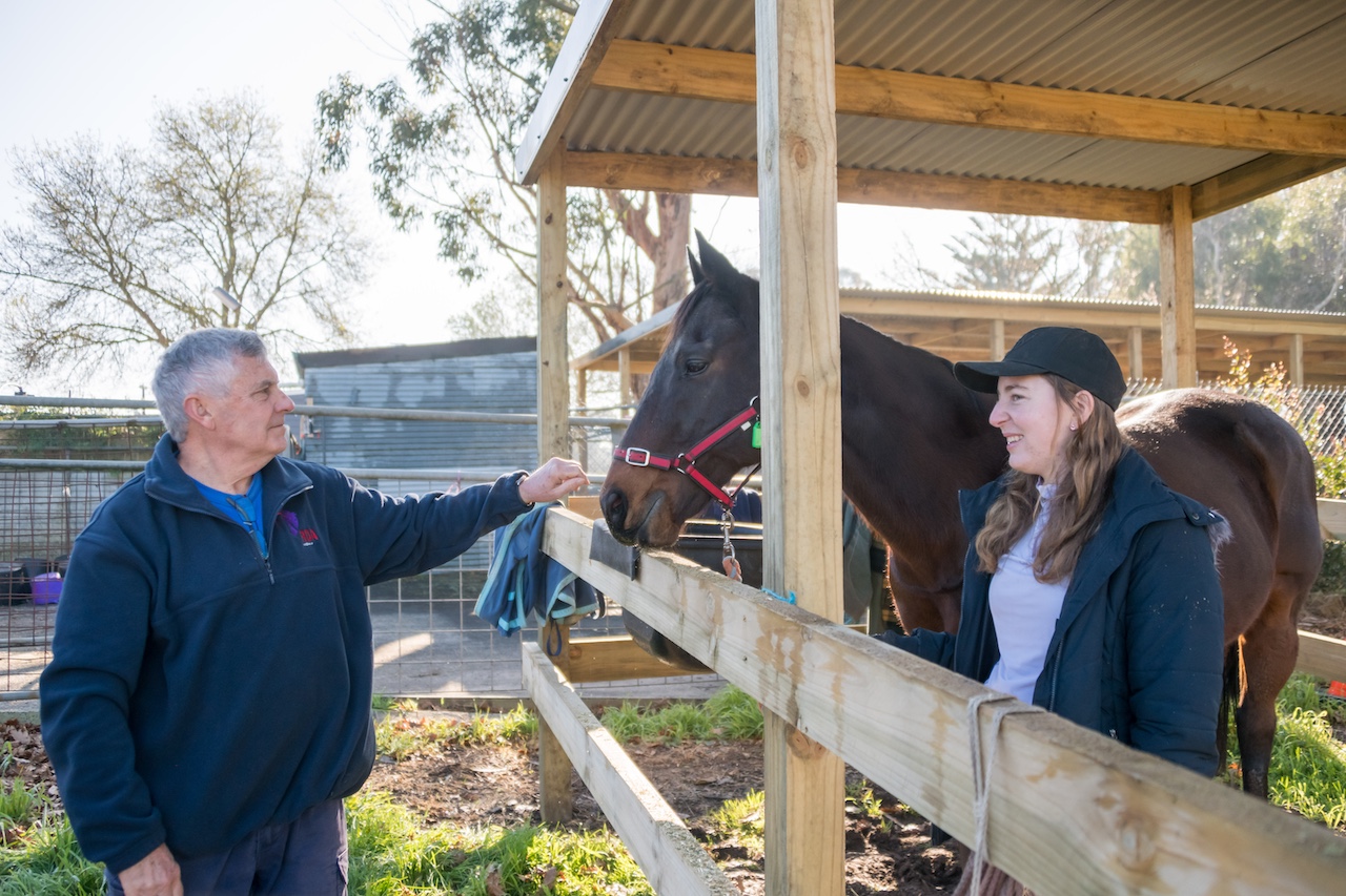 A man and a woman pat a horse