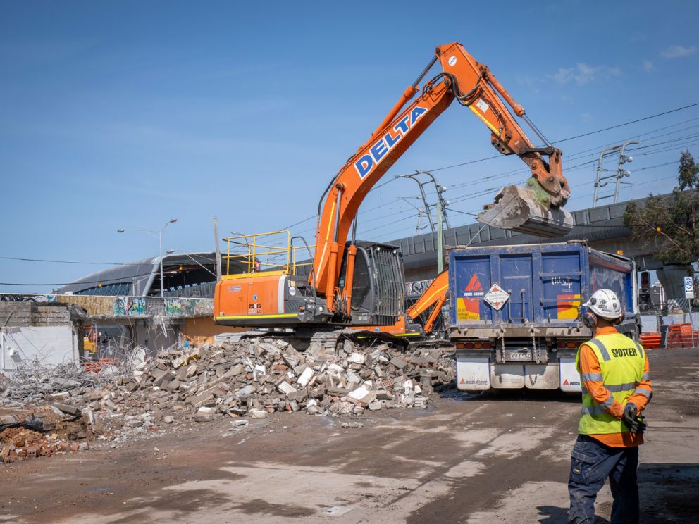 Spotter onsite as trucks move around Clayton Road.