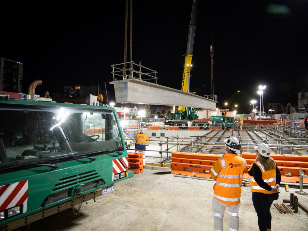 Beams being lifted into place at the Box Hill construction site at night.