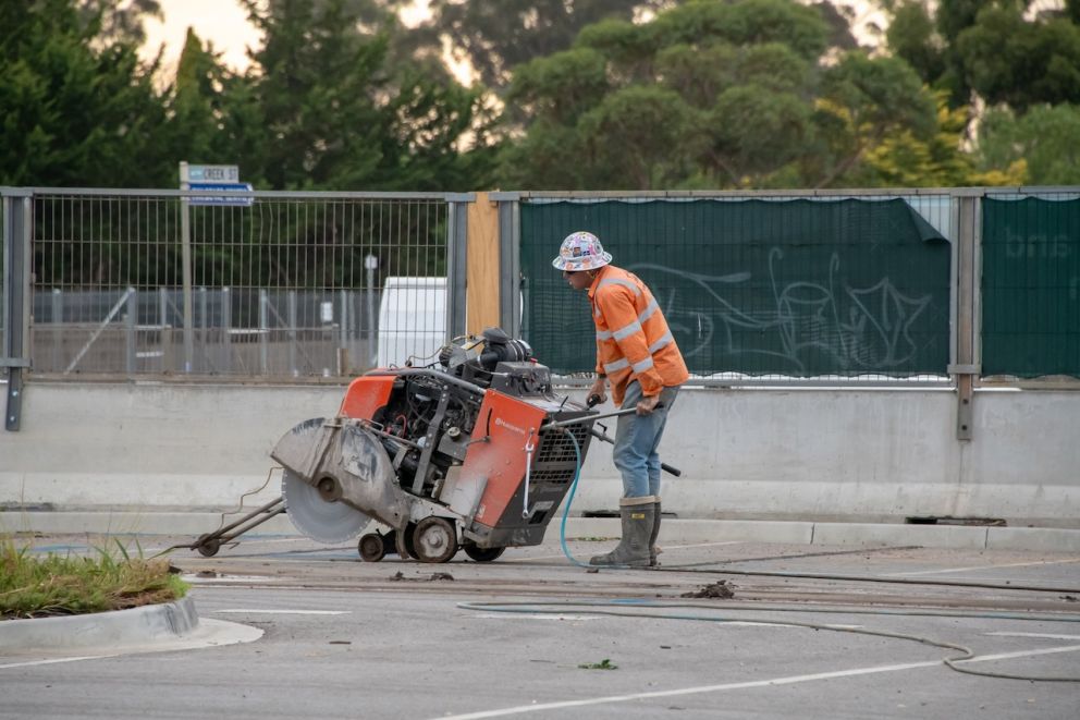 Worker cutting through concrete at Melton Station