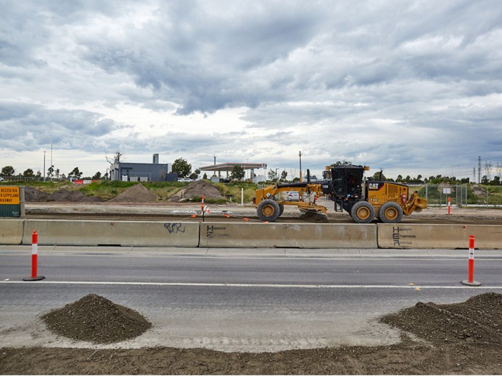 Image shows road in the forefront whereas in the background construction of the road is being done