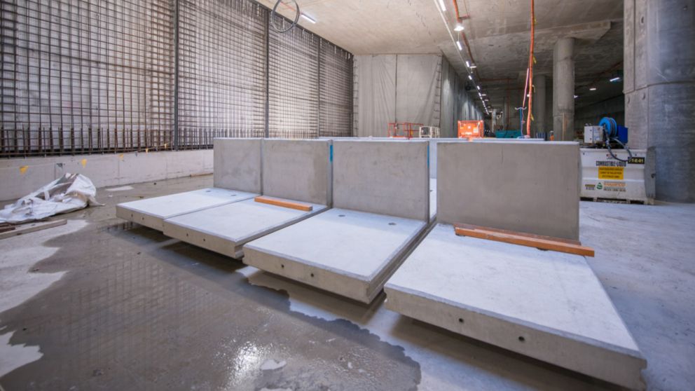 Precast overhead track exhaust panels on the ground in a concrete-covered  room