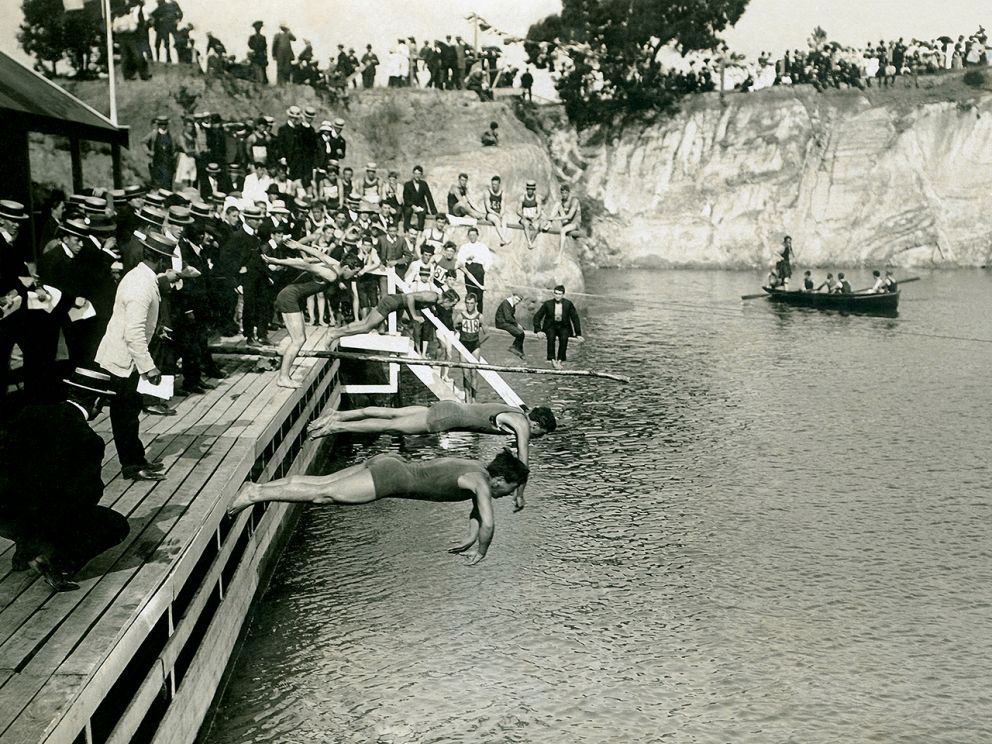 This image shows the Surrey Dive swimming carnival held in the 1930s which contestants mid dive.