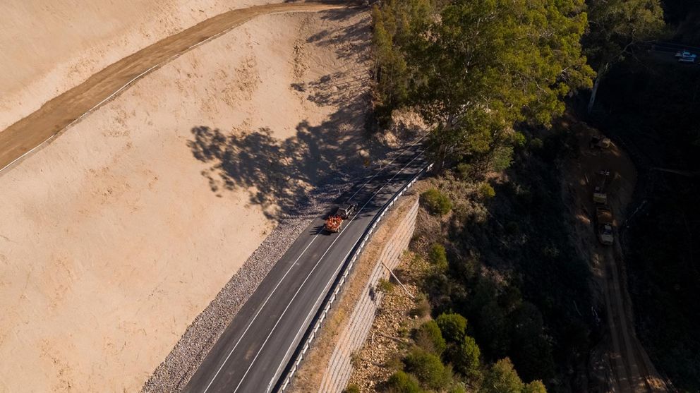 A silver 4wd towing bollards in a trailer travelling along Bogong High Plains Road towards Mt Beauty