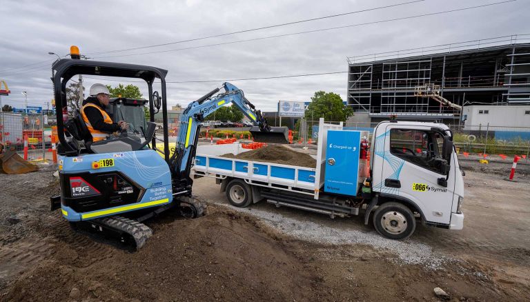 An electric excavator and tip-truck on Pakenham Road Upgrade