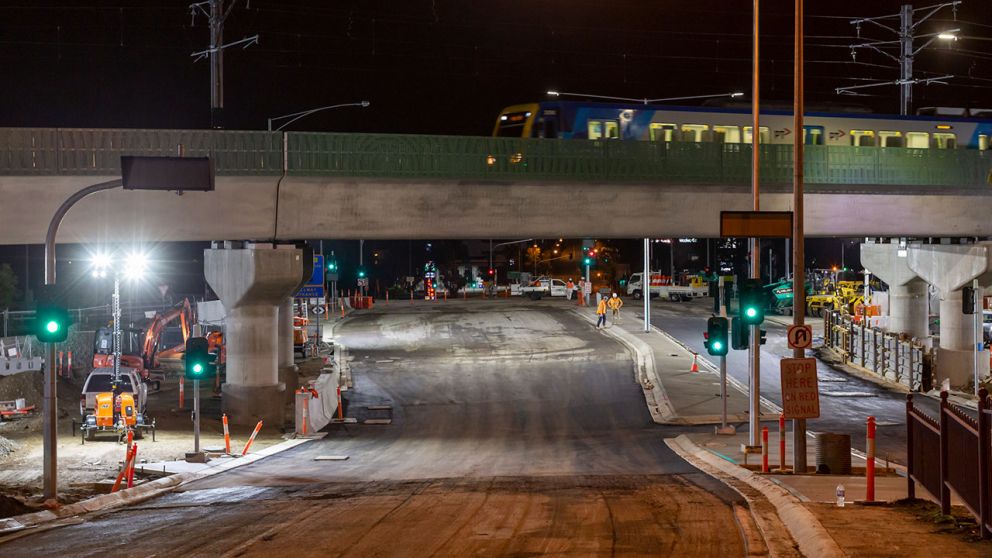 A train passes over the constructed rail bridge as Toorak Road works continue