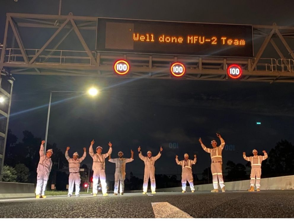 December 2020 New overhead signage between South Gippsland Freeway and Princes Highway completed and turned on. Workers celebrating in front of the new signage.