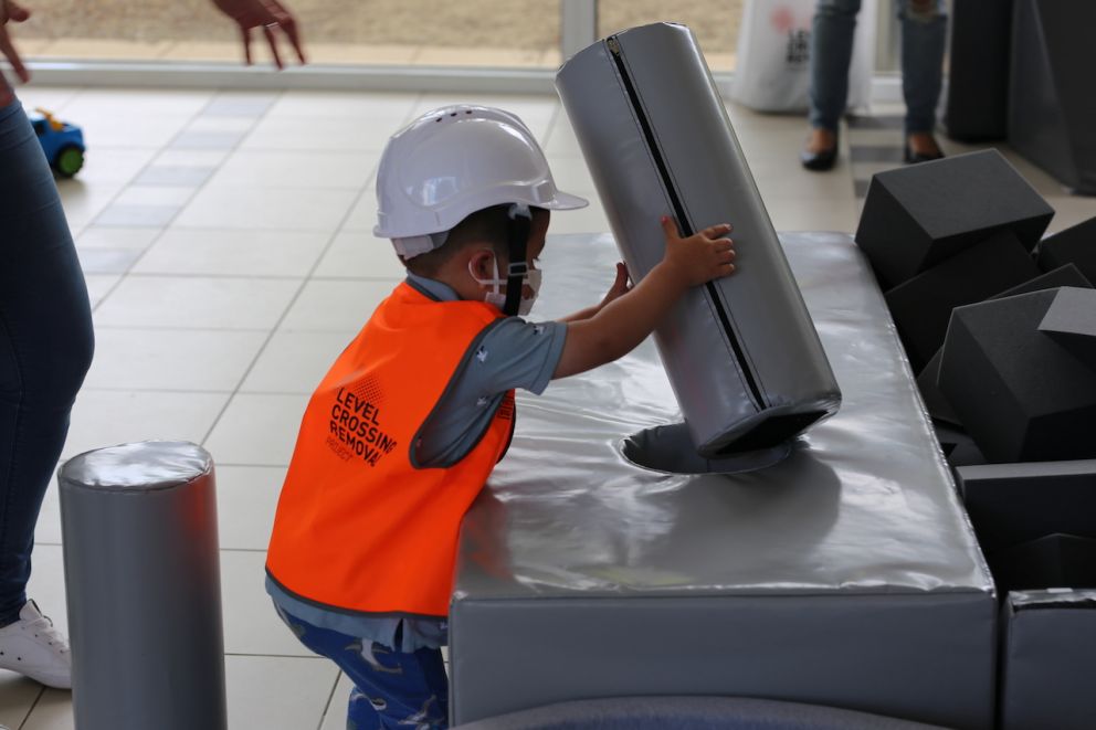 A child placing a foam cylinder into a hole.