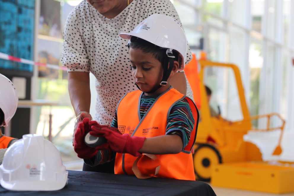 A child wearing hi-vis and a mini hard hat.