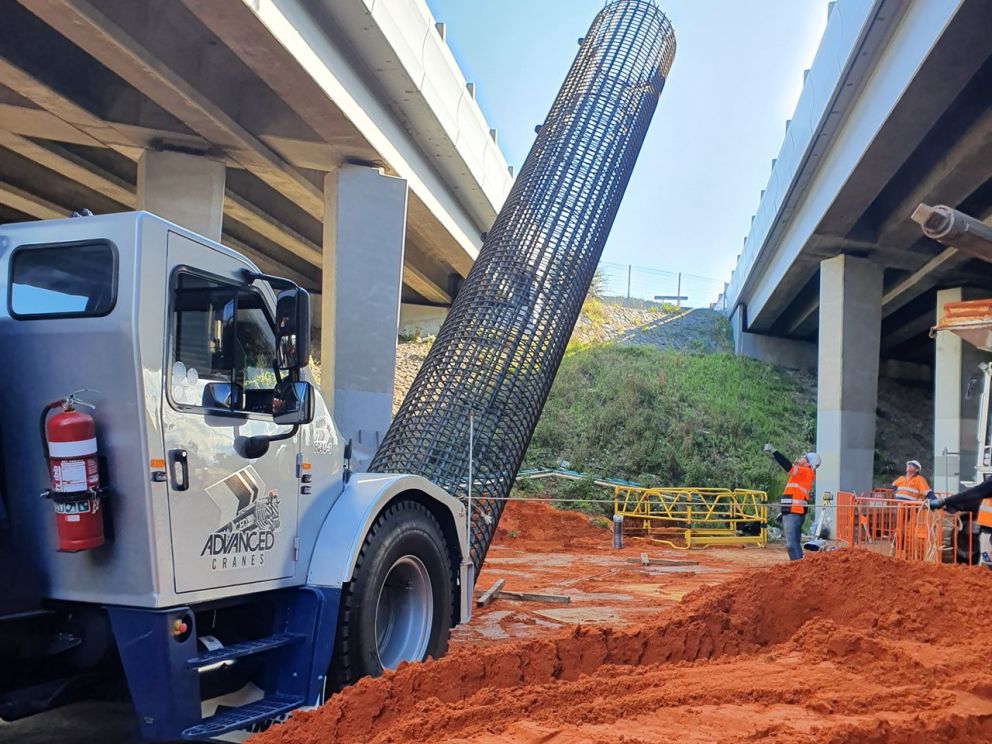 Nov 2020 Commenced piling to support the widened freeway bridge at Ferntree Gully Road. Image shows construction being done beneath the freeway bridge with a crane and workers.Nov 2020 Commenced piling to support the widened freeway bridge at Ferntree Gully Road. Image shows construction being done beneath the freeway bridge with a crane and workers.