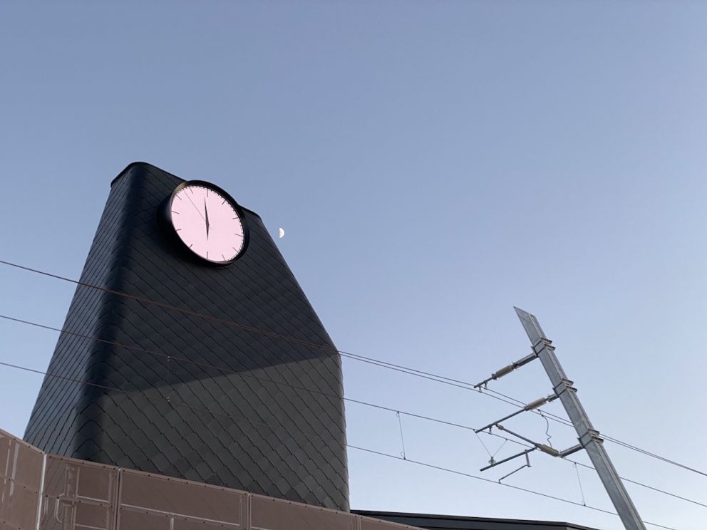 A large clock tower at the new Mooroolbark Station with the moon in the sky.