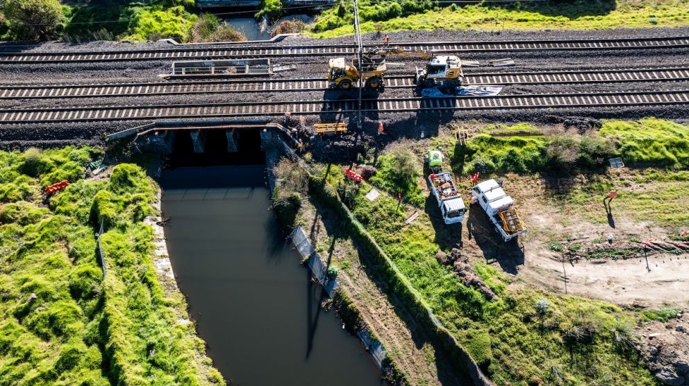 Workers inspect electrical overheads near the Paisley Drain in Williamstown North