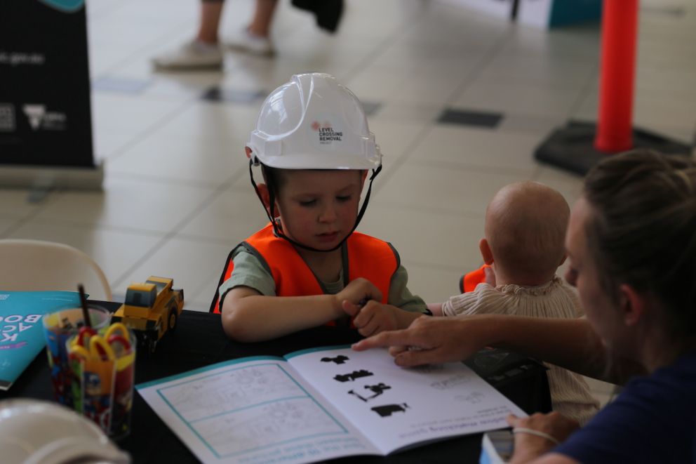 A child sitting at a table, colouring in.