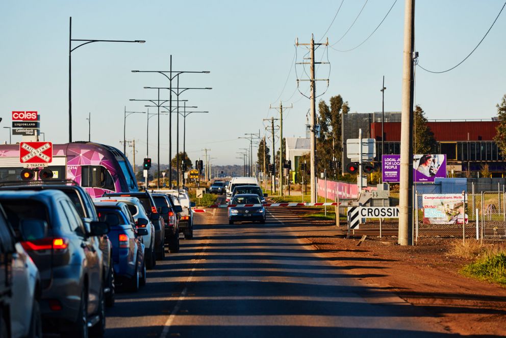Traffic waiting at the Ferris Road, Melton level crossing as a train is passing through