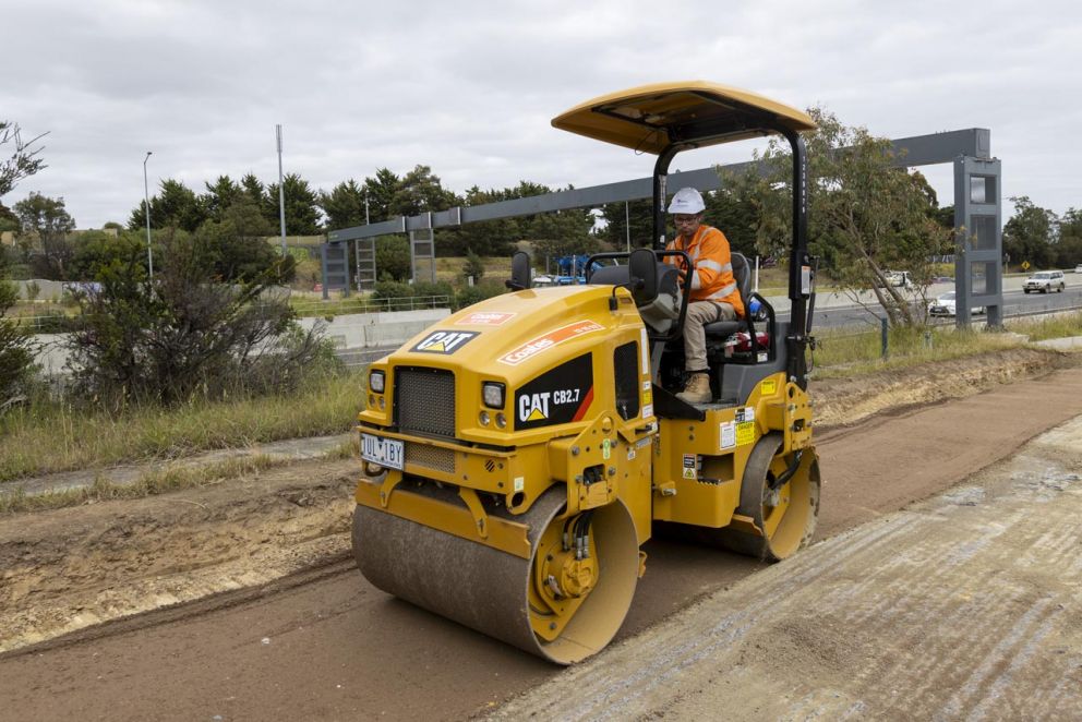 A drum roller compacting materials to create a smooth even surface