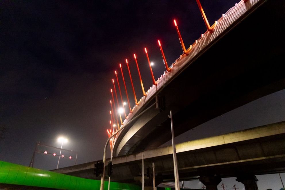 The orange lighting poles next to the walking and cycling bridge at Docklands.