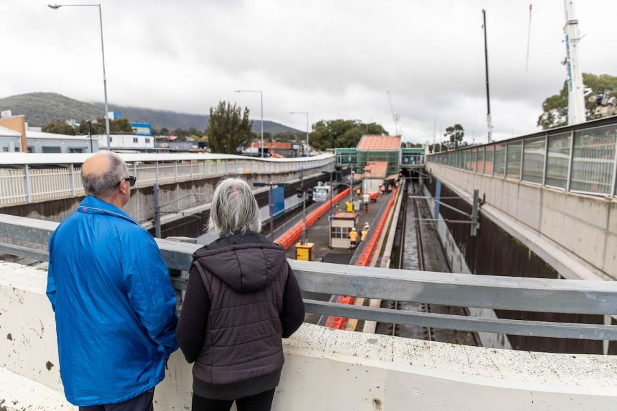 A couple of locals looking down to the new station platforms and along the rail corridor
