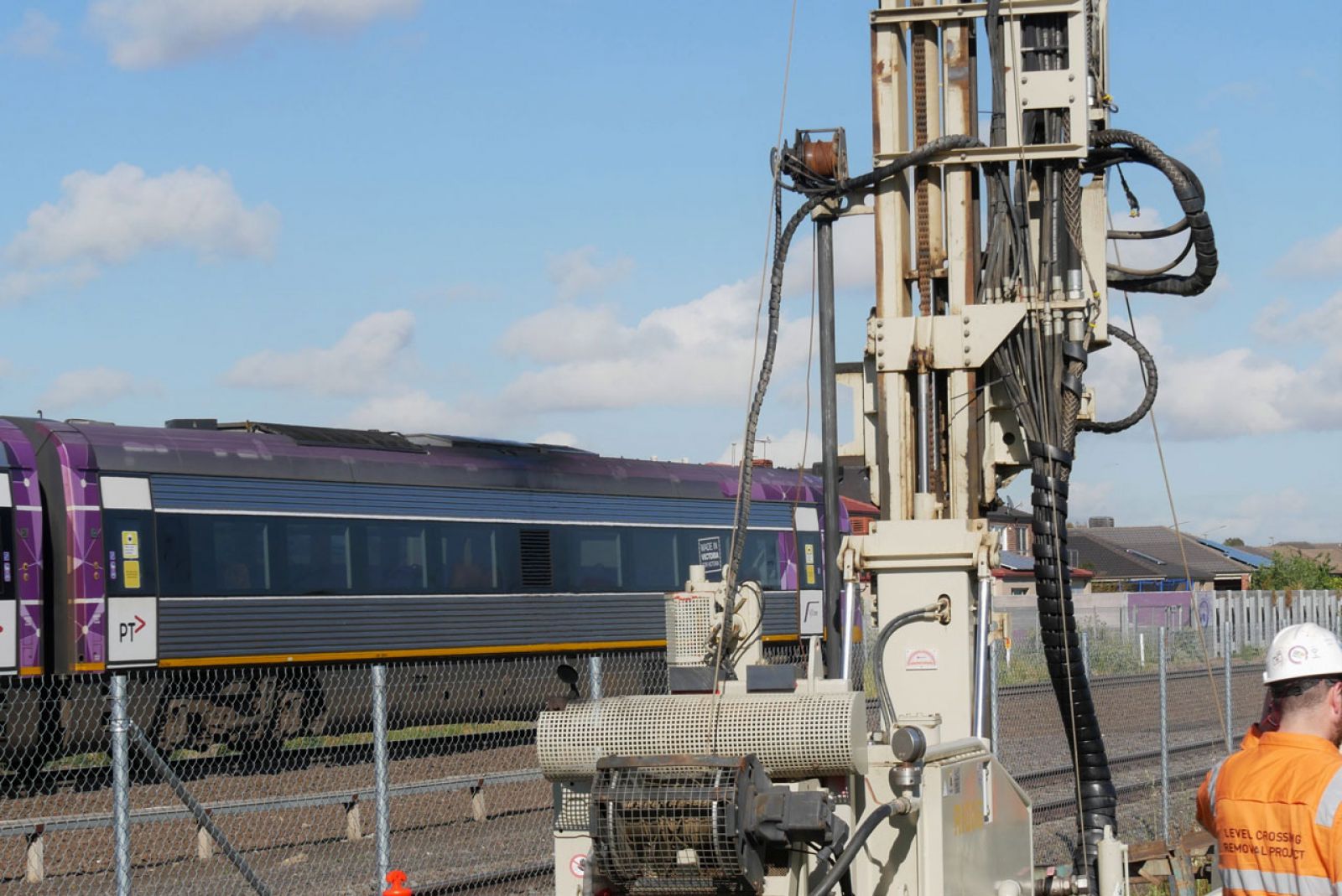 A V/Line train passing our geotech machinery and technicians on site.