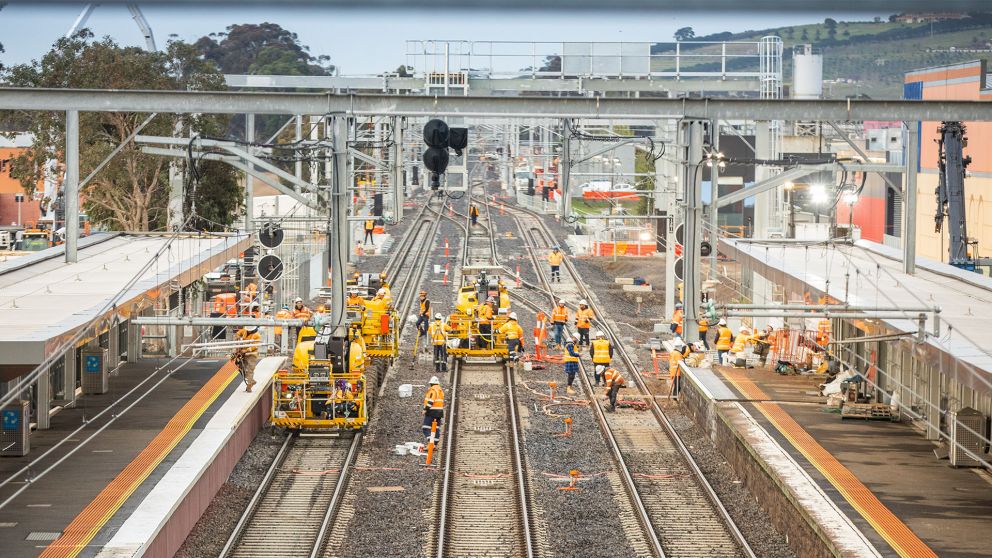 Workers working on an outdoor rail line platform