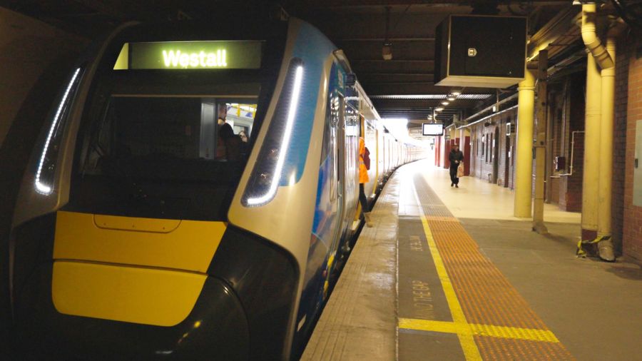 A train with Westall displayed in lights on the front pulls up at a platform.