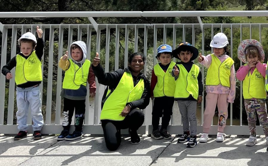 Children and a woman on a bridge giving the thumbs up sign