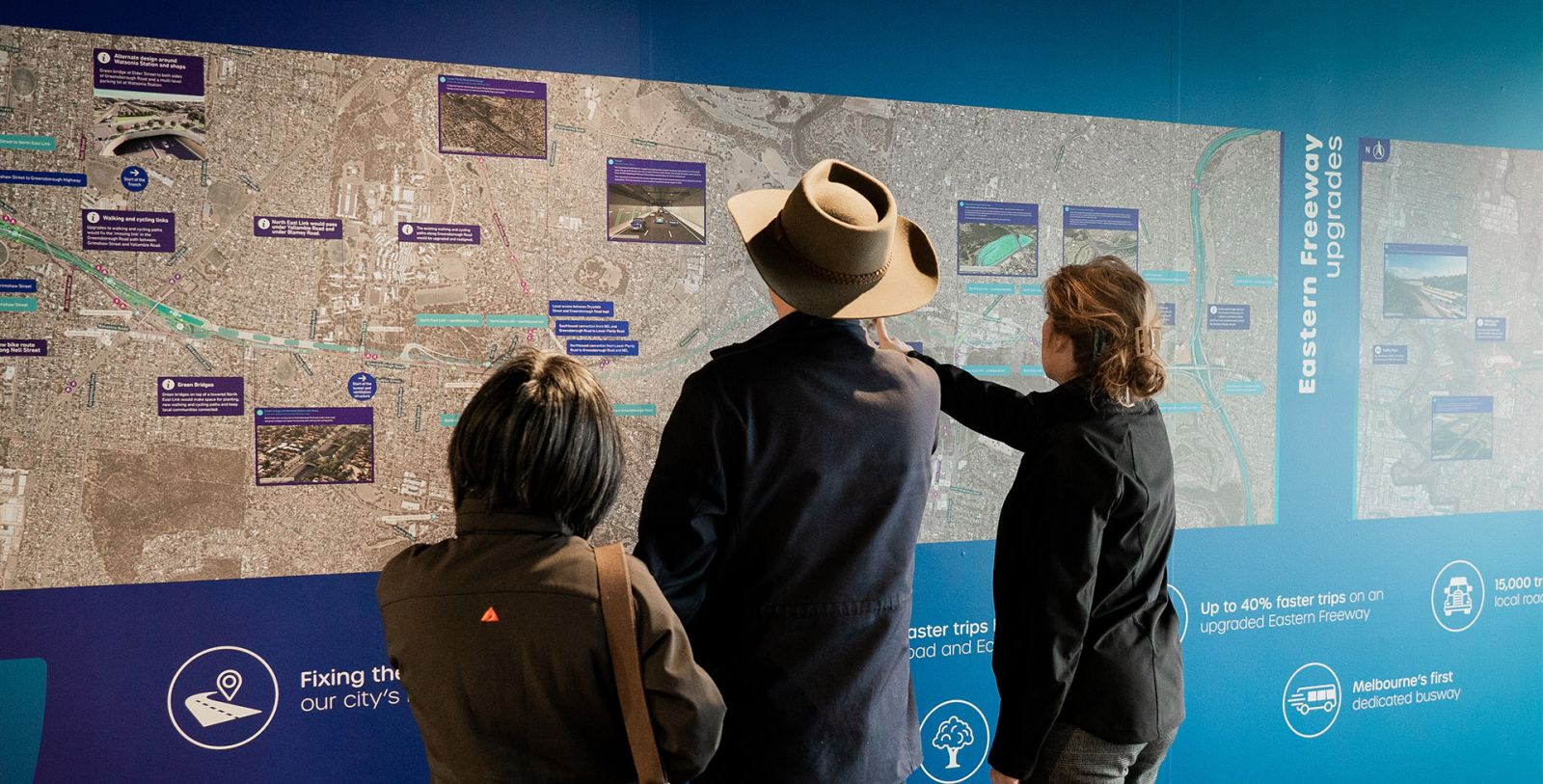 A group of people looking at a map of the proposed North East Link route. 