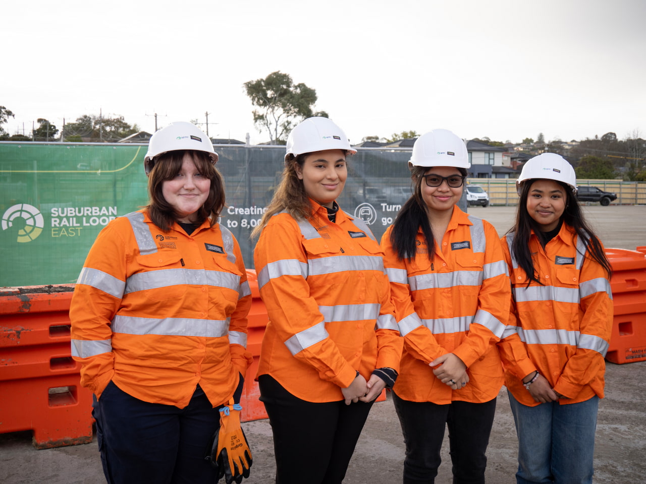 Four teenage girls in high vis clothing and hard hats on an SRL work site