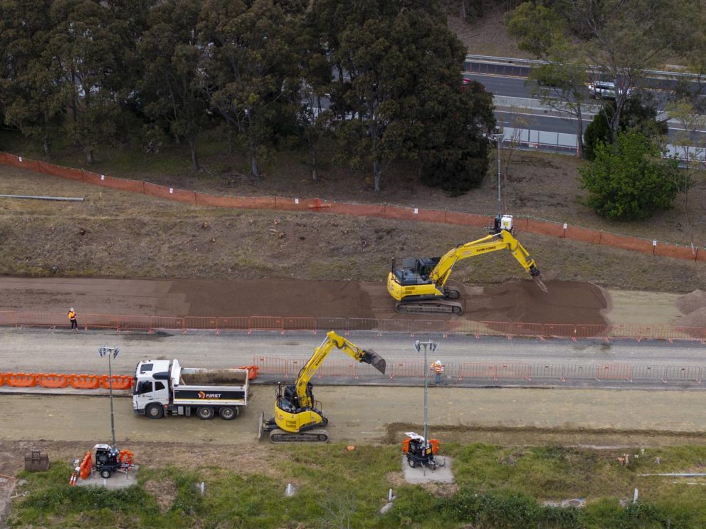 Excavators working to level the surface for widening works